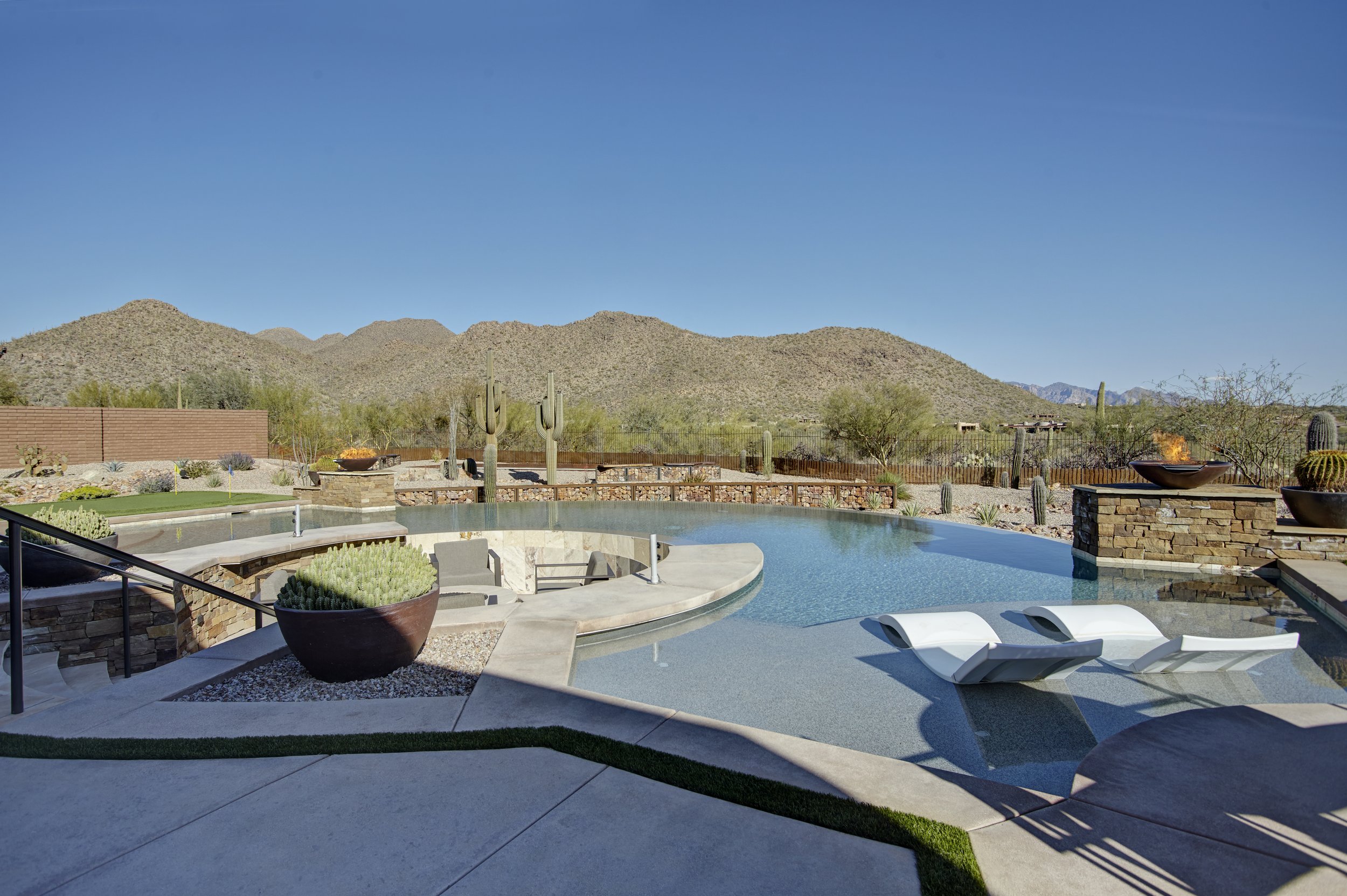 Luxury backyard with pool, desert landscaping, and mountain view